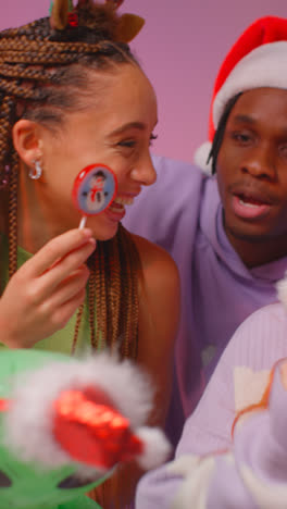 Vertical-Video-Studio-Shot-Of-Gen-Z-Friends-Dancing-At-Christmas-Party-Wearing-Santa-Hat-And-Reindeer-Antlers-1